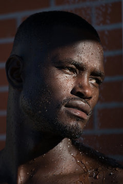 Close-up of man with wet face against wall