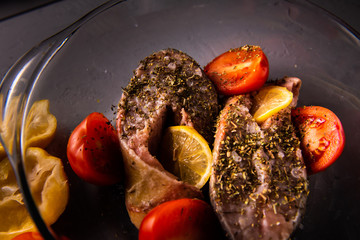  cooking salmon dishes on a concrete table in a transparent baking sheet with ingredients laid out around