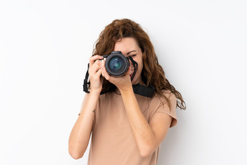 Young pretty woman over isolated background with a professional camera