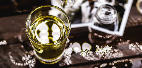 alcoholism and divorce. Fallen drink glasses on wooden table, torn family photo. Concept of divorce and addiction problems with drinking.