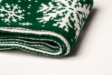 Close-up of a piece of green scarf folded into several layers with white snowflakes