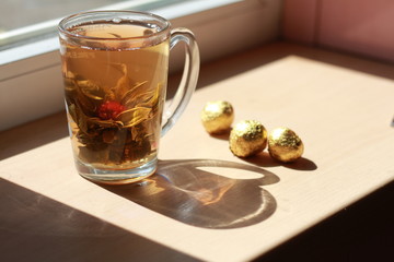 Delicious and fragrant golden tea stands on the windowsill.