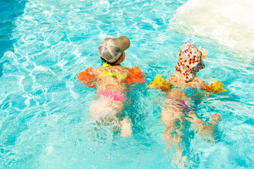 two little kids playing in the swimming pool