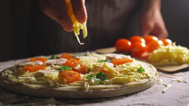 Close up view of a man chef cooking italian pizza. The process of making pizza at table in bakery. Fresh dough on kitchen table