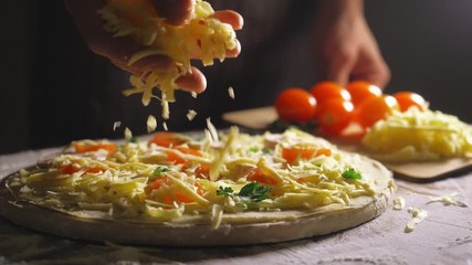 Close up view of a man chef cooking italian pizza. The process of making pizza at table in bakery. Fresh dough on kitchen table