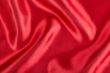 Red silk fabric background. Abstract texture. Close up.