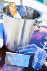Romantic luxury evening on cruise yacht with champagne setting. Empty glasses and bottle with champagne and tropical sunset with sea background