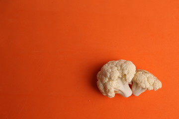 Pieces of raw cauliflower in color background