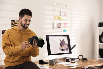 Professional photographer with camera working in light modern office