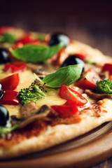Healthy pizza with ham, broccoli, cherry tomatoes, red pepper and champignon mushrooms. Close up.