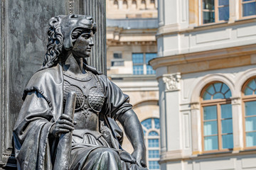 Fototapeta na wymiar Old statue of a sensual woman warrior, Amazonian, as defender with lion head and club at the Neumarkt in downtown of Dresden, Germany, details, closeup