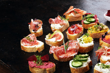 Assorted bruschetta with various toppings. Appetizing bruschetta or brie crostini. Variety of small sandwiches. Mix bruschetta on table