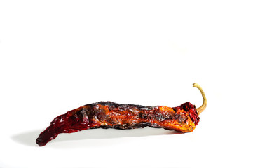 Hot chili peppers in dried form with a bright multicolored color. One on a white background, isolated horizontal location, copy space. Wasteless production. Ugly.