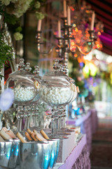 A sweet table with desserts and sweets in purple colors. Marshmallows in glass vases. Decor luxury wedding celebration.