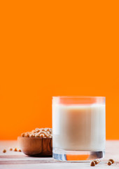 Soy milk and soy bean on orange background. Non-dairy milk concept. Vegan Drink. Copy space
