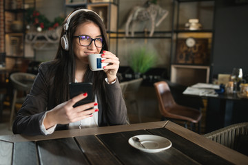 Portrait of young woman drinking coffee and listen music