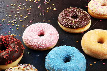 assorted donuts with chocolate frosted, pink glazed and sprinkles donuts