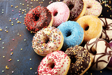 assorted donuts with chocolate frosted, pink glazed and sprinkles donuts