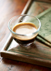 Coffee in glass cup on rustic wooden background. Close up.