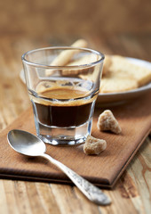 Coffee in glass cup on rustic wooden background. Close up.