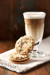 Almond cookies and cafe latte on brown wooden background.	