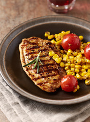 Grilled Turkey Breast with sweet corn. Rustic background. 