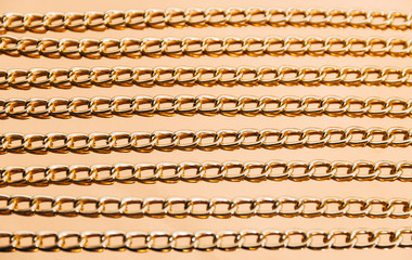 Shiny golden chains on reflective surface