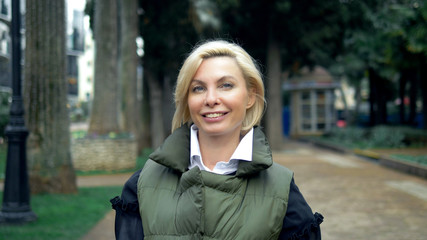 beautiful stylish trendy blond woman walking in a city Park in autumn
