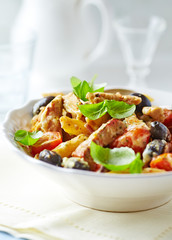 Penne pasta with fried pork tenderloin, cherry tomatoes and black olives. Oven baked.