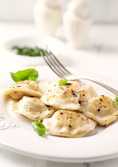 Dumplings with potato and cottage cheese stuffing (pierogi). Traditional Polish Christmas Dinner. Bright background.