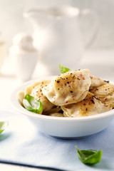 Dumplings with potato and cottage cheese stuffing (pierogi). Traditional Polish Christmas Dinner. Bright background.