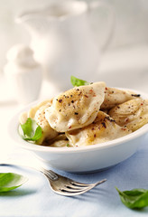 Dumplings with potato and cottage cheese stuffing (pierogi). Traditional Polish Christmas Dinner. Bright background.