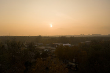 Aerial drone photography of sunset over a hazy cityscape in Europe. 
