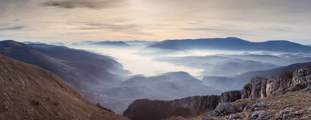 Foto auf Alu-Dibond Panorama of Dry mountain (Suva planina) in Serbia, valley filled with thick fog, rocky foreground and colorful sunrise sky © Nikola