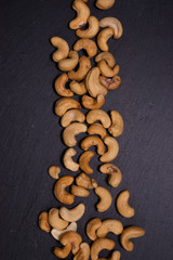 Salted cashew nuts on a black background. Healthy snack