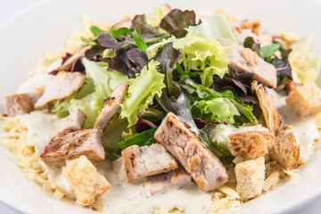 Classic Caesar Salad with mixed vegetables, homemade croutons, parmesan cheese, meat and dressing