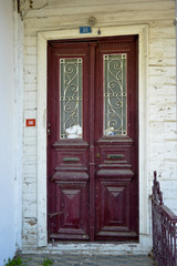 Old claret red wooden entrance door of house