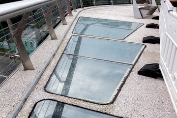 pedestrian bridge with gravel and glass inserts, closeup of construction details, nobody.