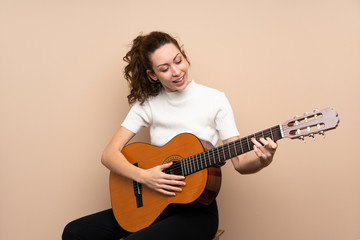 Fototapeta premium Young woman with guitar over isolated background