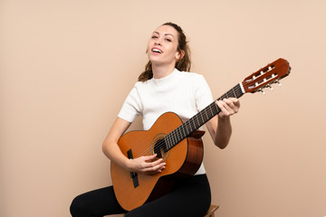 Fototapeta premium Young woman with guitar over isolated background