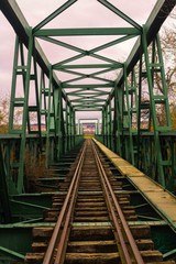 Vista  a través de un puente. Vista a través de vías de tren abandonadas en un día nublado