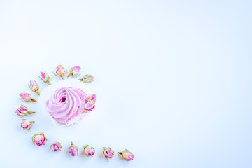 Abstract image made by pink fruit marshmallow and dried pink flowers on the white background with copy space. 