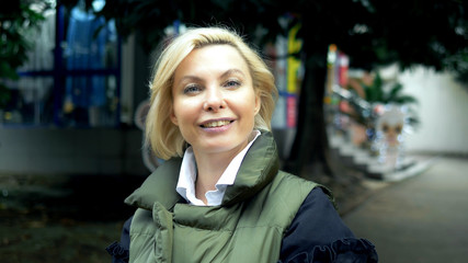 beautiful stylish trendy blond woman walking in a city Park in autumn