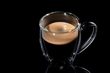 black coffee in a glass transparent cup on a black background