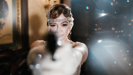 close-up of a woman in the image of 20s holding a diodema in her gun on her head, hairstyle wave,
