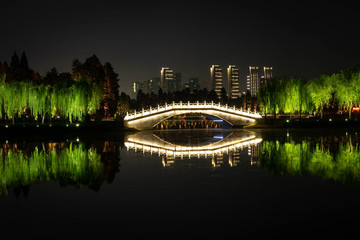Night view of  Chinese bridge with light decoration at East Lake and city skyline