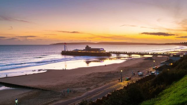 Bournemouth, UK. Aerial view of famous Pier in Bournemouth, England, UK during the sunset. Time-lapse with moving waves of the sea., panning video
