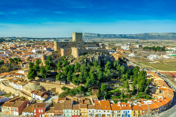 Aerial view of medieval Almansa castle with donjon and courtyard on a rock emerging from the plateau surrounded by a circular ring of red roof houses in Spain, site a famous battle