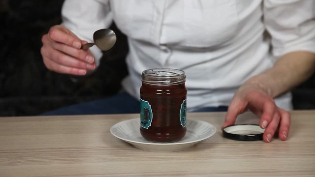  Eatable pine cones jam (made in Latvia). Woman is eating pine cones jam. Cure from flu and delicious food