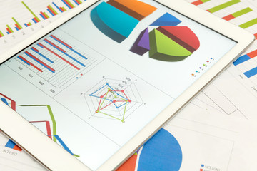 Financial charts on the table with tablet